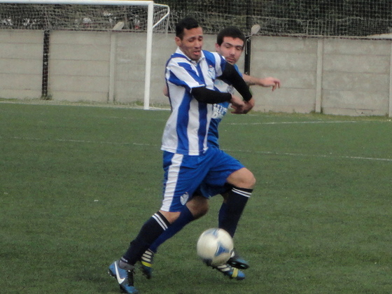 El Pocho Mora aguanta el balón pese a la presión. El "10" es el estratega de Villa G. Gálvez.