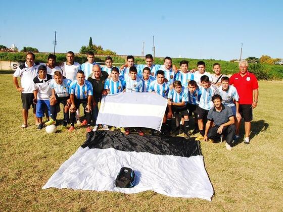 Jugadores y cuerpo técnico posan junto a Tito y las banderas de Argentina y la de Sparta.