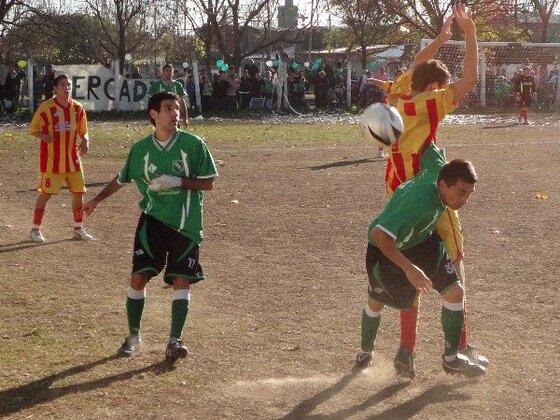 Hernández se agacha para buscar el balón. Camafreita, del Defe, levanta los brazos. Y Sigal mira de cerca.