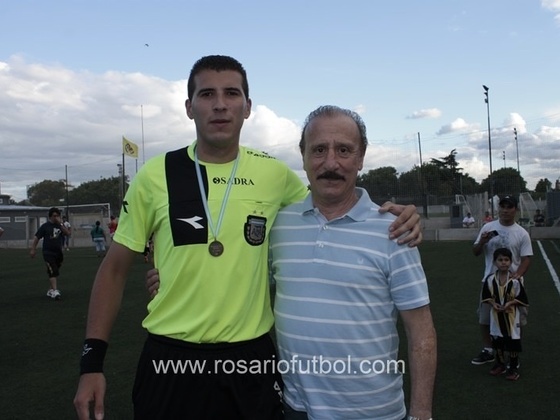 Julián Martinez recibe su medalla de manos de Aldo Poy por haber dirigido los 4 partidos de la jornada