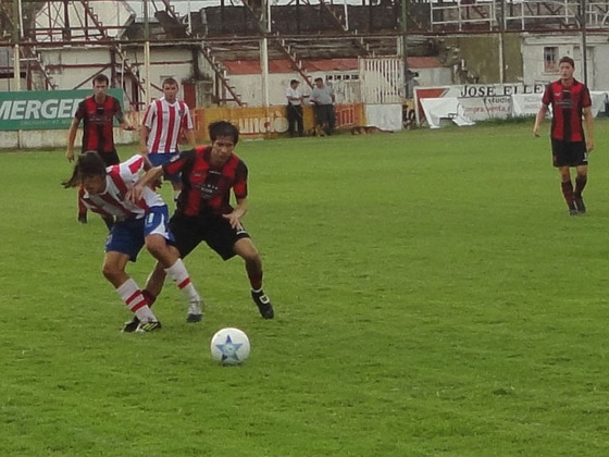Iván Aguirre y Falcón luchan por un balón sobre el lateral del campo. Carcarañá fue más.