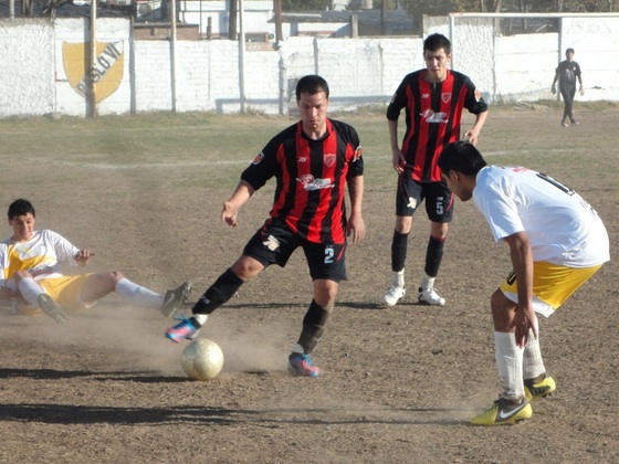 Eduardo Aguirre intenta salir prolijamente del fondo, y enfrenta al autor del gol, Barrios.