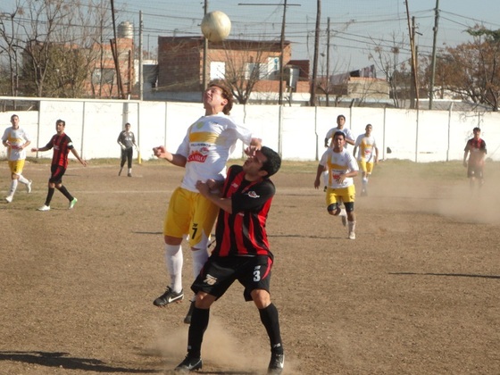 El colorado Jonatan Gene salta a cabecear, y le gana arriba a Víctor Vilches de Unión.