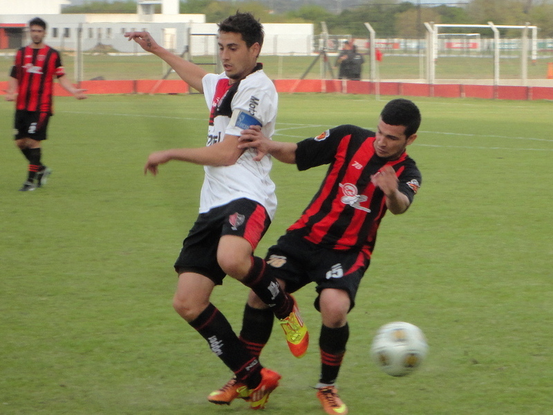Francisco Fydriszewski, capitán y goleador de NOB, aguantando la presión de Mauricio Olivo.