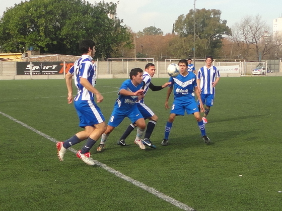Medina y Ayala de General Paz, los autores de los goles, miran el balón y rodean a Oscar Mora.