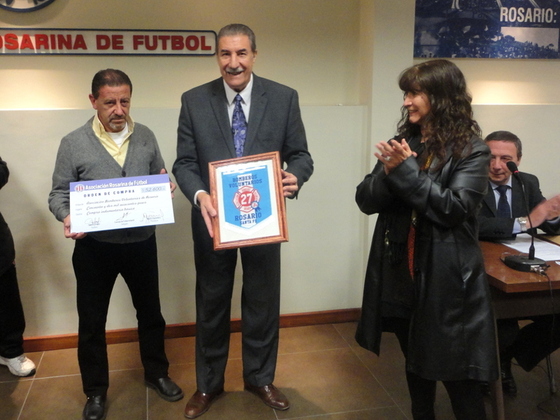 Eduardo López, Presidente de la ABVR, muestra el cheque simbólico donado a los Bomberos.