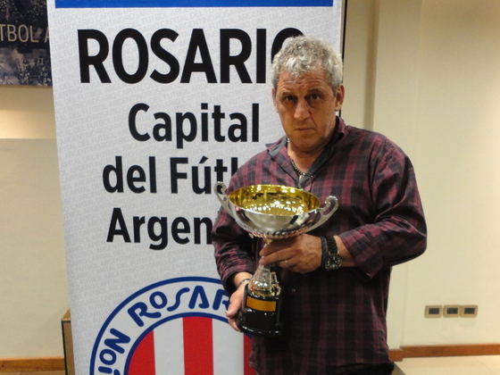 Juan Carlos Alberto, delegado de Semillero, mostrando la copa de 7ma División A3.