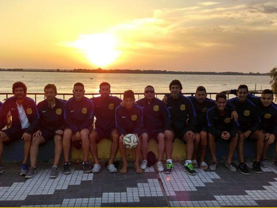 Una linda postal del plantel de fútbol playa canalla, con la puesta de sol de fondo.