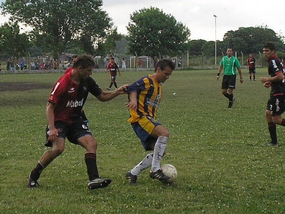 Diógenes Urcia aguanta el balón ante la presión de varios jugadores rojinegros. Fue en el epílogo del cotejo.