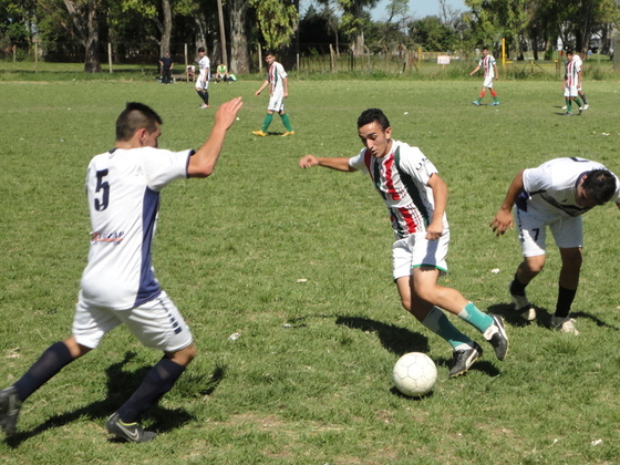 El "hongo" Bertolano y el "pato" Pissano intentan recuperar un balón, cuando faltaba poco.
