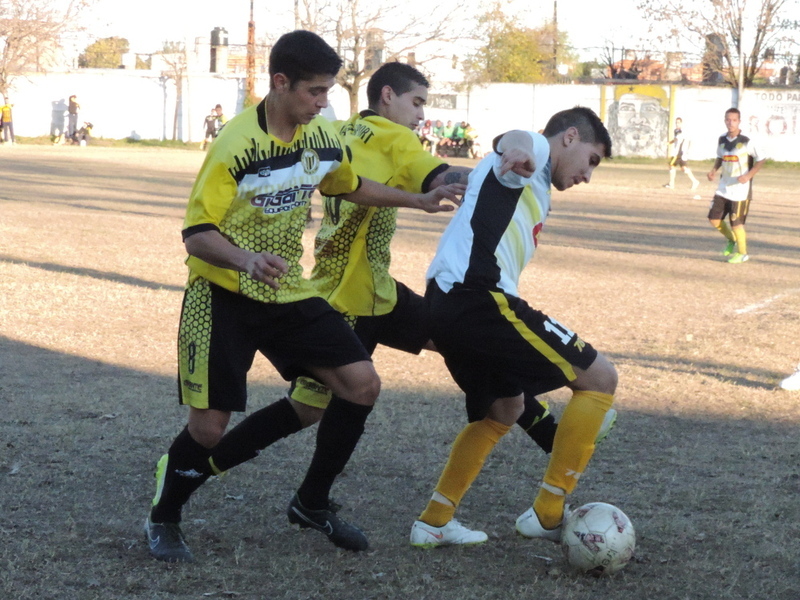 Lucas Ortega de Oriental, aguanta una pelota de espaldas, pese a la presión de dos rivales.