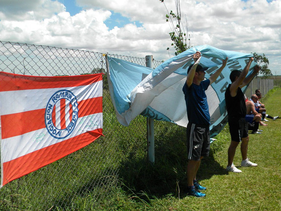Dos muchachos de Rosario tapándose el sol con la bandera argentina que siempre está.