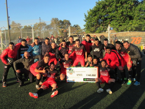 El plantel de Unión festeja la clasificación con el cheque simbólico del Banco Santa Fe.