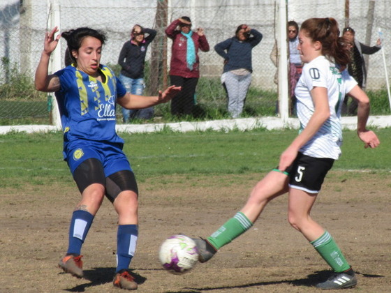 Lonigro, la goleadora del torneo, intenta obstruir la salida de la batalladora Delma González.