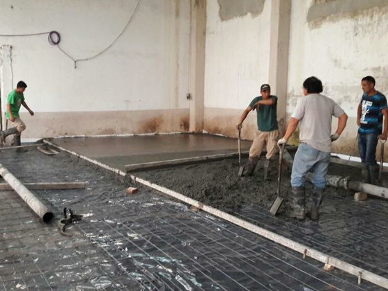Una foto de la obra en pleno proceso, con los trabajadores terminando el piso.