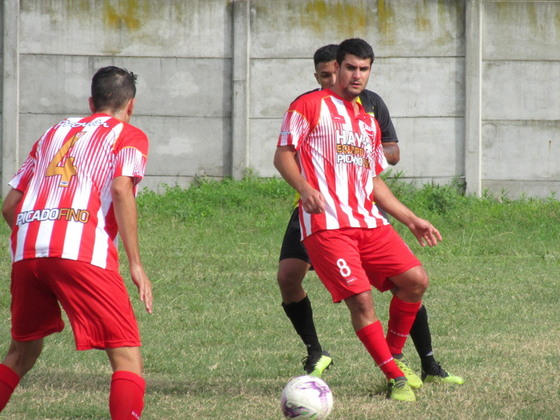 Ciraolo apoyándose en Juani Tumini, lateral del rojo que fuera el goleador de Provin en 2018.