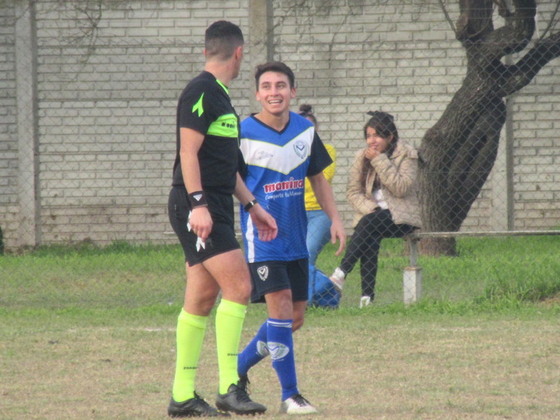 Braian Gamarra acaba de convertir su gol, y el árbitro lo acompaña hasta el mediocampo.