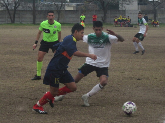 Matías Maidana intentando eludir a un rival. El árbitro Mapelli siguiendo de cerca la jugada.